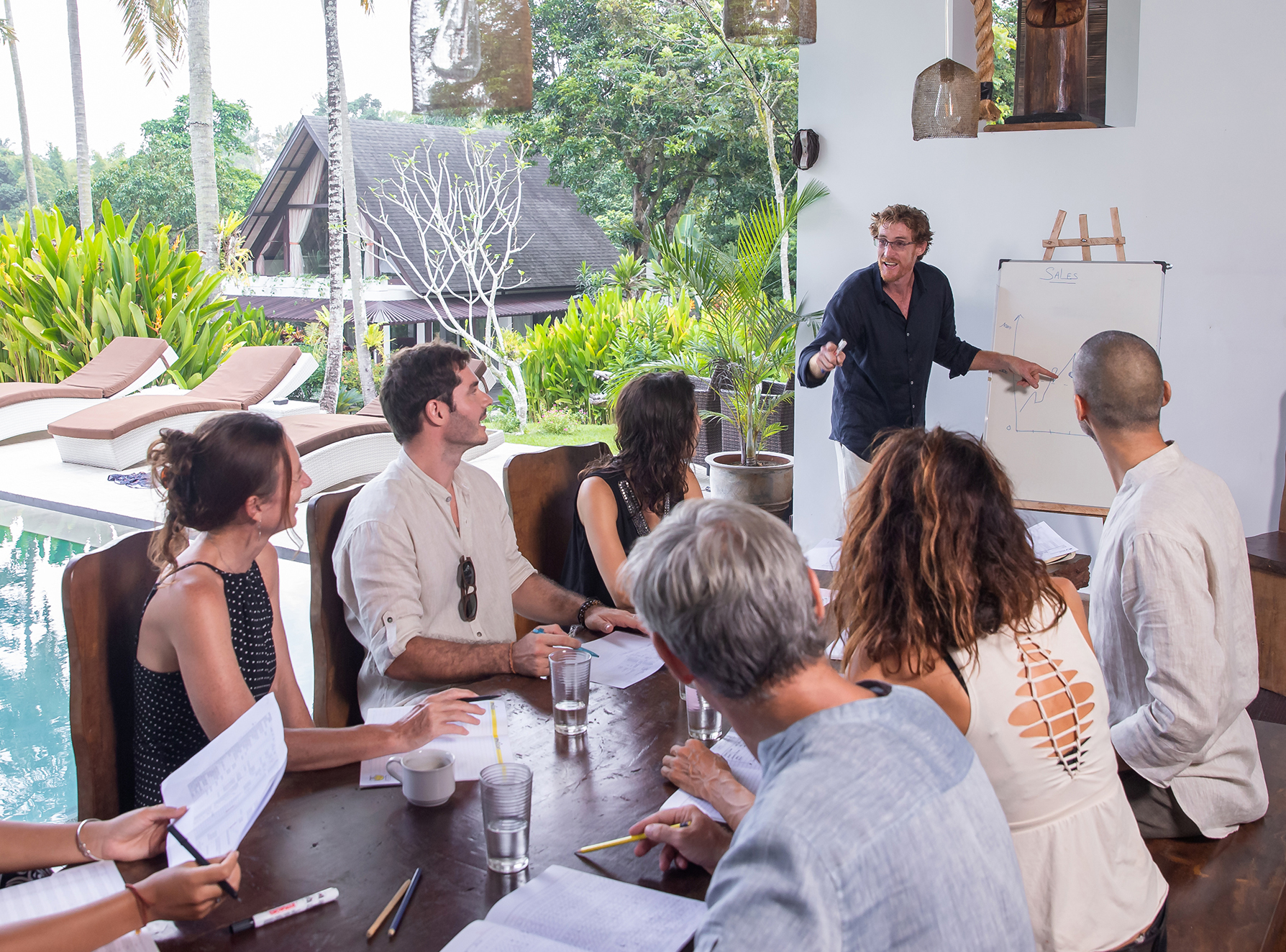 An enthusiastic presenter, leading a corporate meeting at a resort.