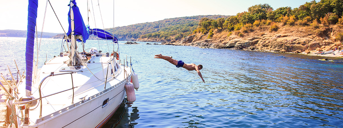 Man diving off of a private yacht. Man diving off of a private yacht.