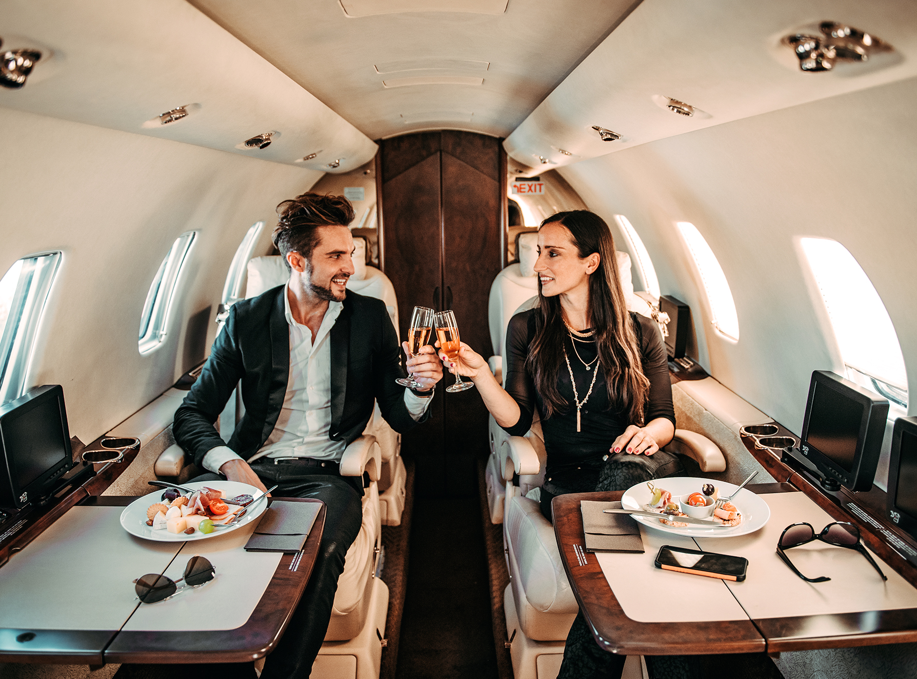 A couple clinking champagne flutes in a private plane.